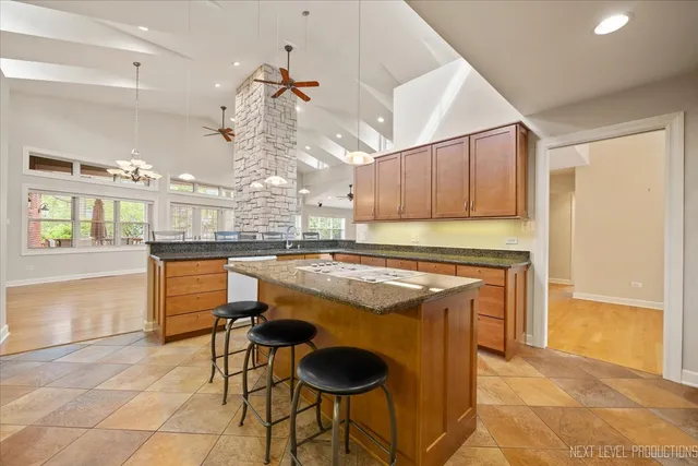 a kitchen with granite countertop a stove a sink and a refrigerator