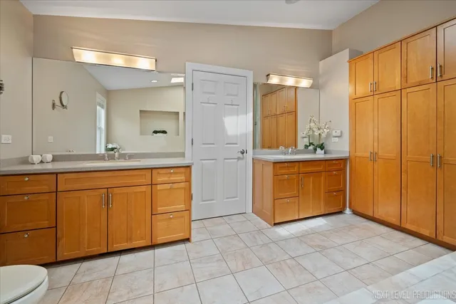 a bathroom with a sink a toilet and large mirror