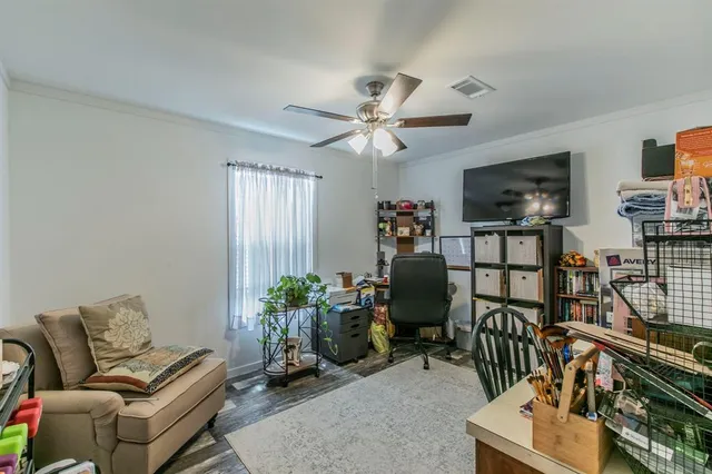 a living room with furniture a flat screen tv and a window