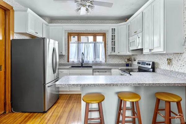 a kitchen with stainless steel appliances granite countertop a stove a sink and white cabinets