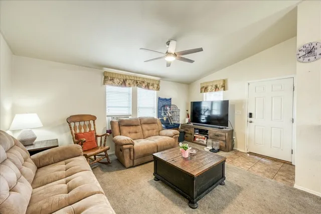 a living room with furniture a chandelier and a flat screen tv
