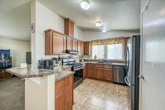 a kitchen with stainless steel appliances granite countertop a sink stove and refrigerator