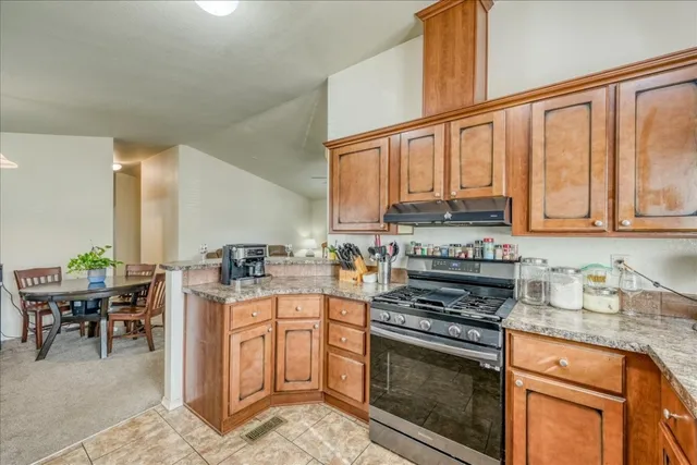 a kitchen with stainless steel appliances granite countertop a stove a sink and a microwave