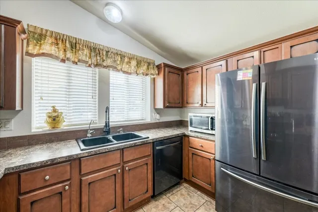 a kitchen with stainless steel appliances granite countertop a refrigerator and a sink