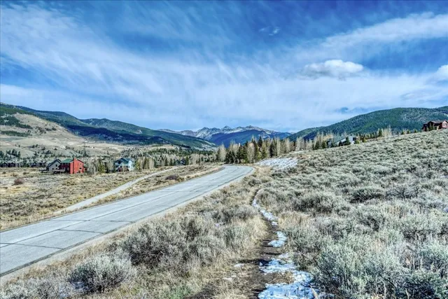 a view of a dry yard with mountains in the background