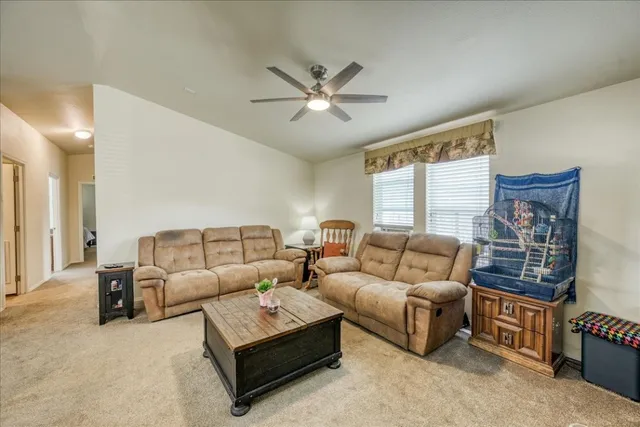 a living room with furniture and a ceiling fan