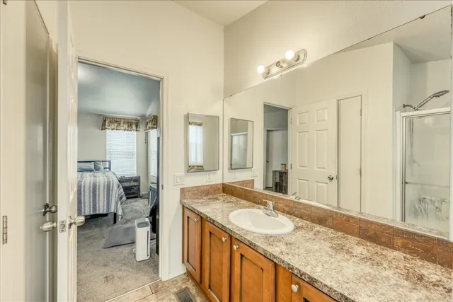 a spacious bathroom with a granite countertop sink and a mirror