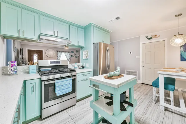 a kitchen with stainless steel appliances kitchen island granite countertop a stove a refrigerator and a dining table