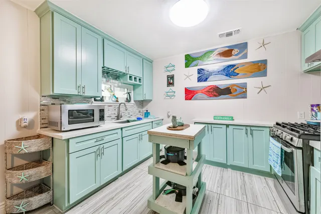 a kitchen with a sink a stove and cabinets