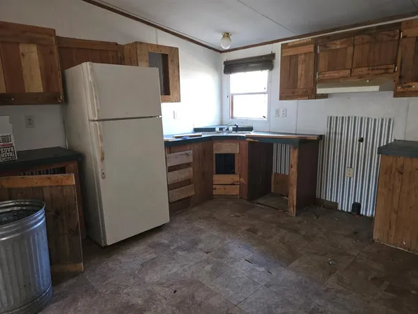 a kitchen with granite countertop a refrigerator and a stove top oven