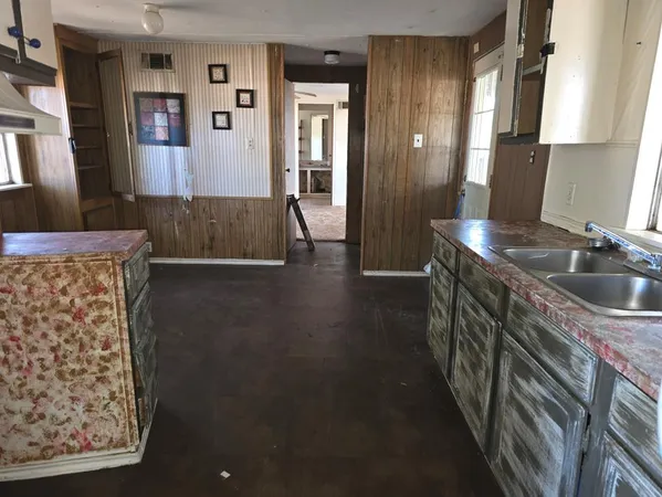 a kitchen with granite countertop a sink and a refrigerator