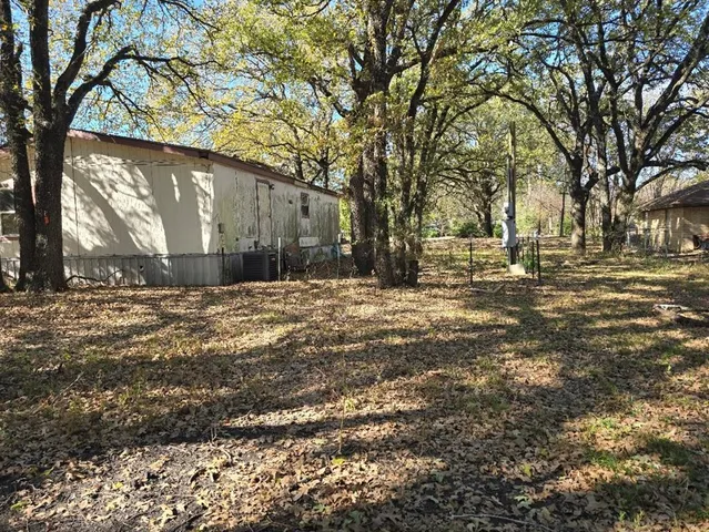 a view of a backyard with large trees and plants