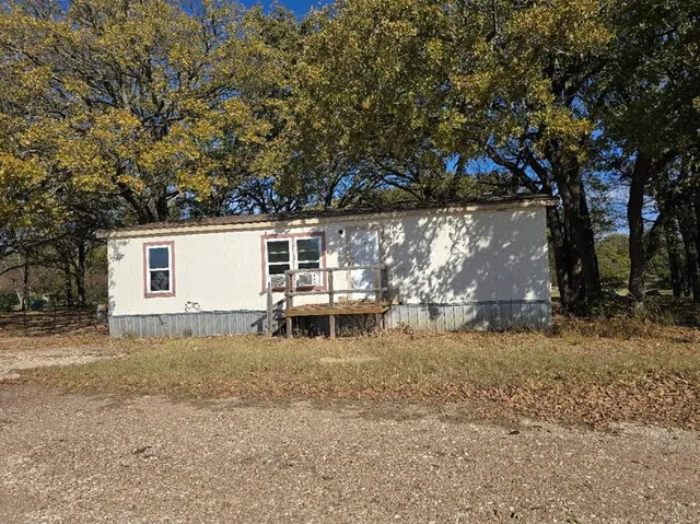 a view of a backyard with a small cabin and a chair