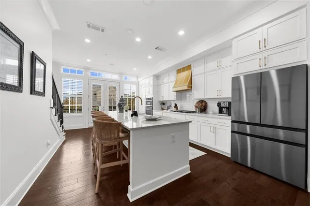 a large kitchen with granite countertop a large window and stainless steel appliances