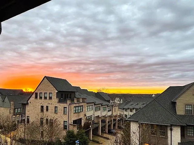 a view of a white house with a big yard and large trees