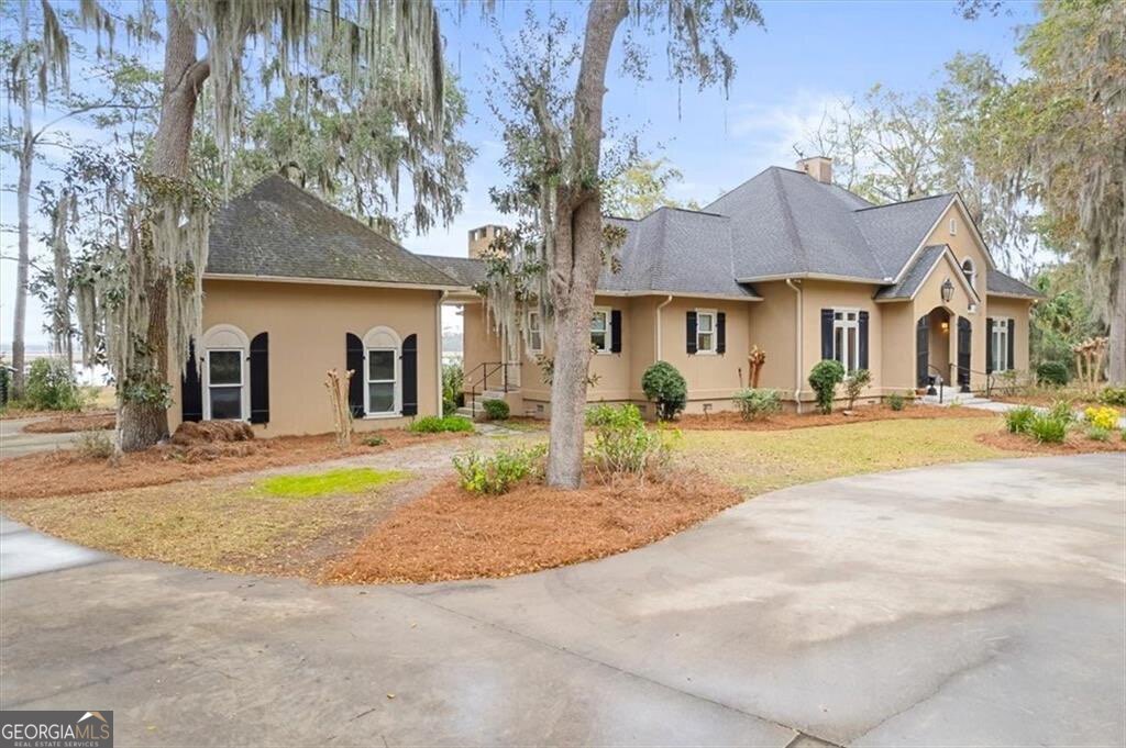 1045 River Club Road Northeast Townsend, GA 31331 - Photo 63 of 85 a front view of a house with a yard and potted plants