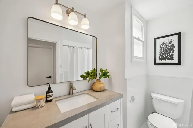 a bathroom with a toilet a sink and mirror