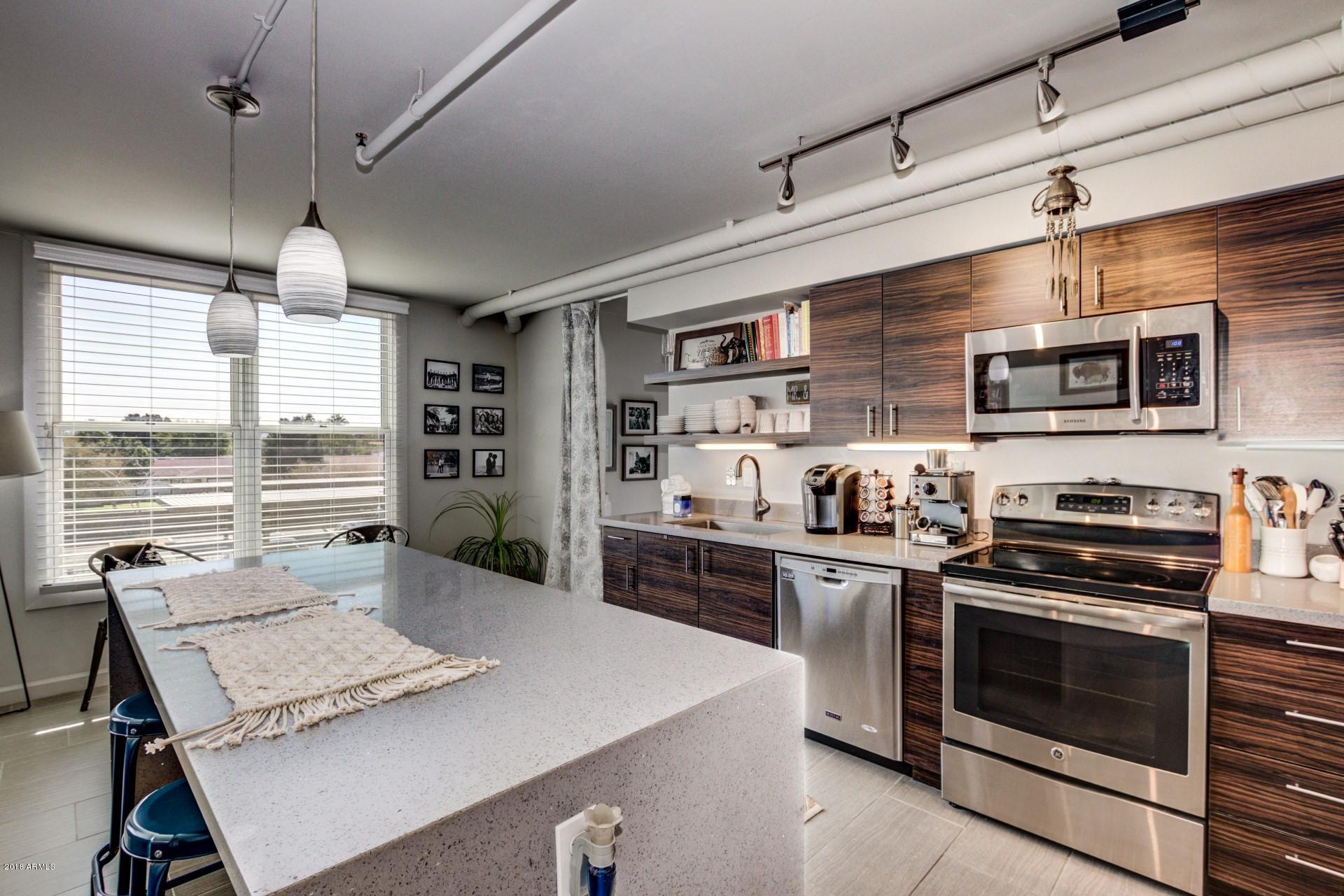 535 West Thomas Road, Unit 208 Phoenix, AZ 85013 - Photo 4 of 22 a kitchen with a stove a sink and wooden floor