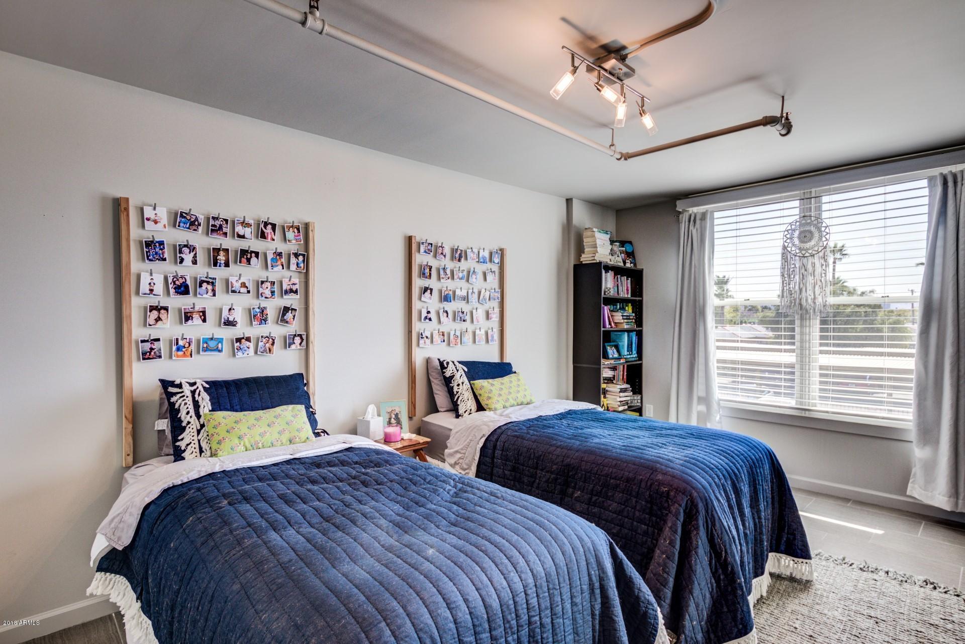 535 West Thomas Road, Unit 208 Phoenix, AZ 85013 - Photo 9 of 22 a bedroom with a bed a dresser and a large window