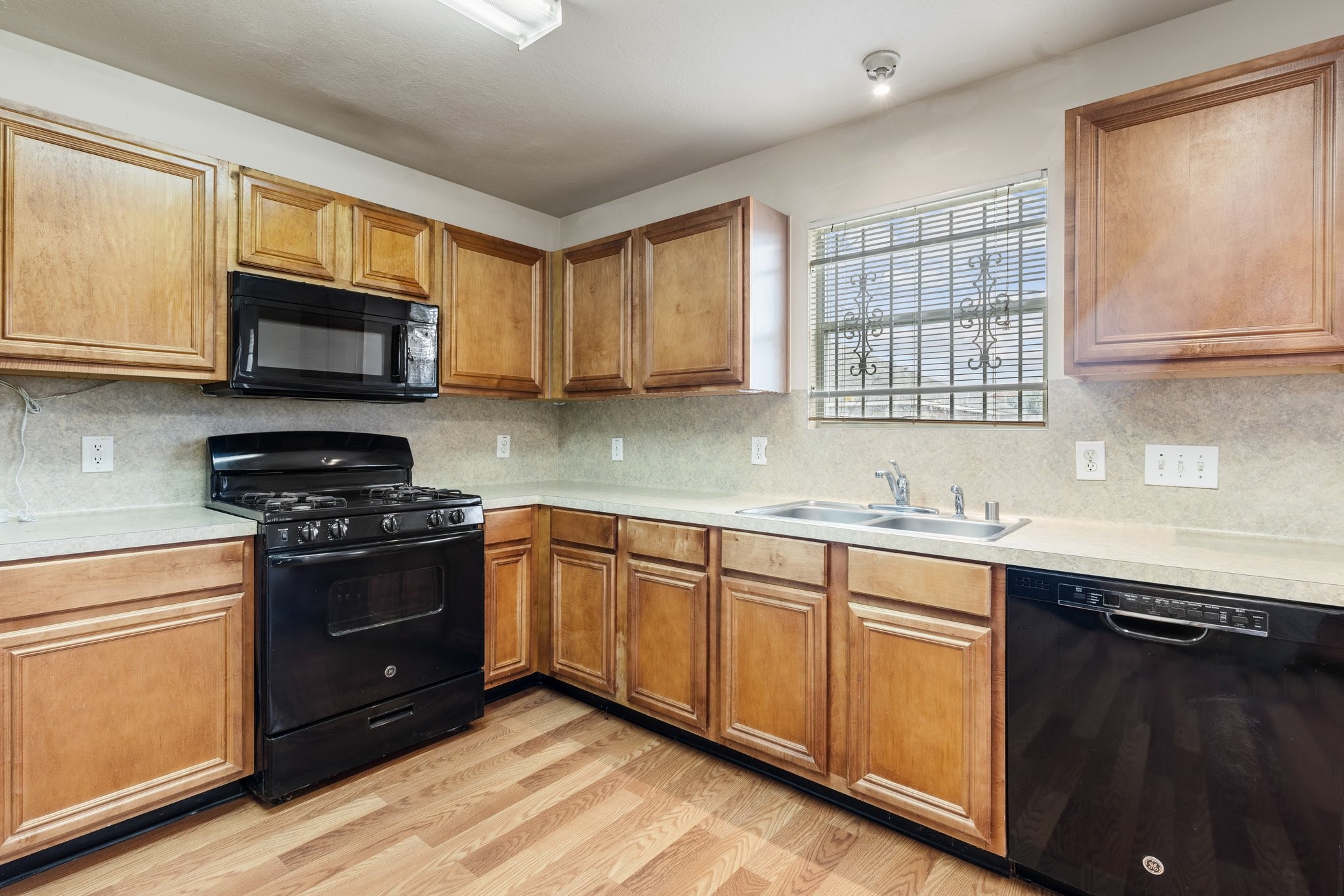 3111 Holly Ranch Drive Katy, TX 77494 - Photo 11 of 28 a kitchen with granite countertop wooden cabinets stainless steel appliances and a window