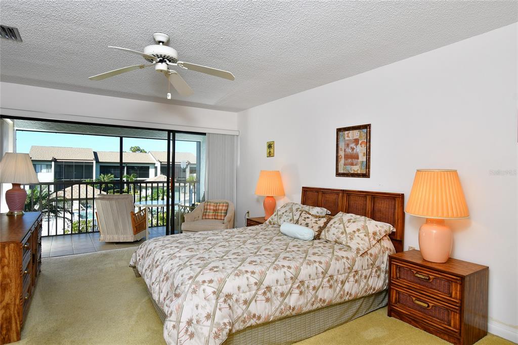 2001 Little Pine Circle, Unit 11B Punta Gorda, FL 33955 - Photo 18 of 45 a bedroom with a large bed and a chandelier