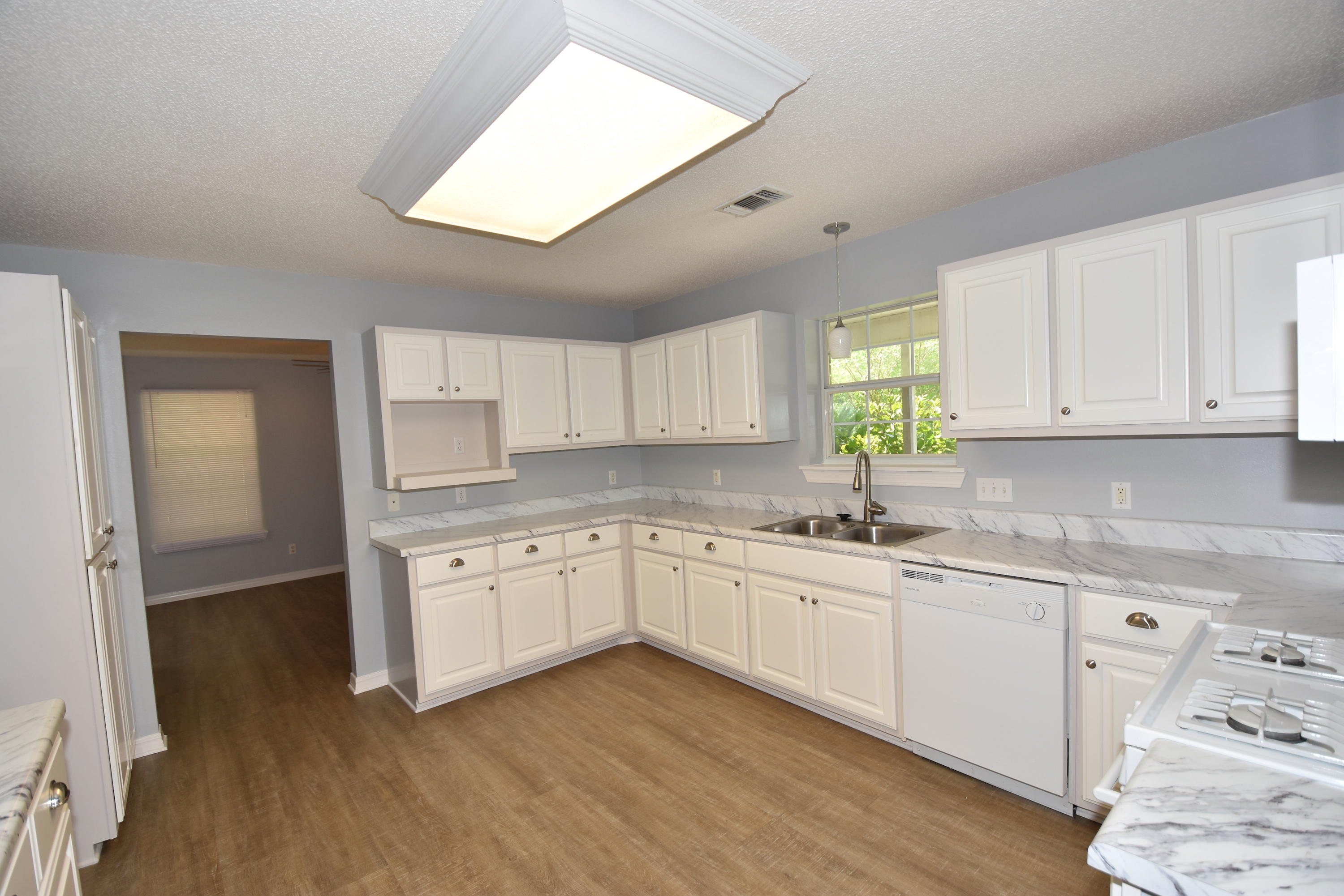 5817 Dairy Road Baker, FL 32531 - Photo 11 of 36 a kitchen with granite countertop white cabinets and white appliances
