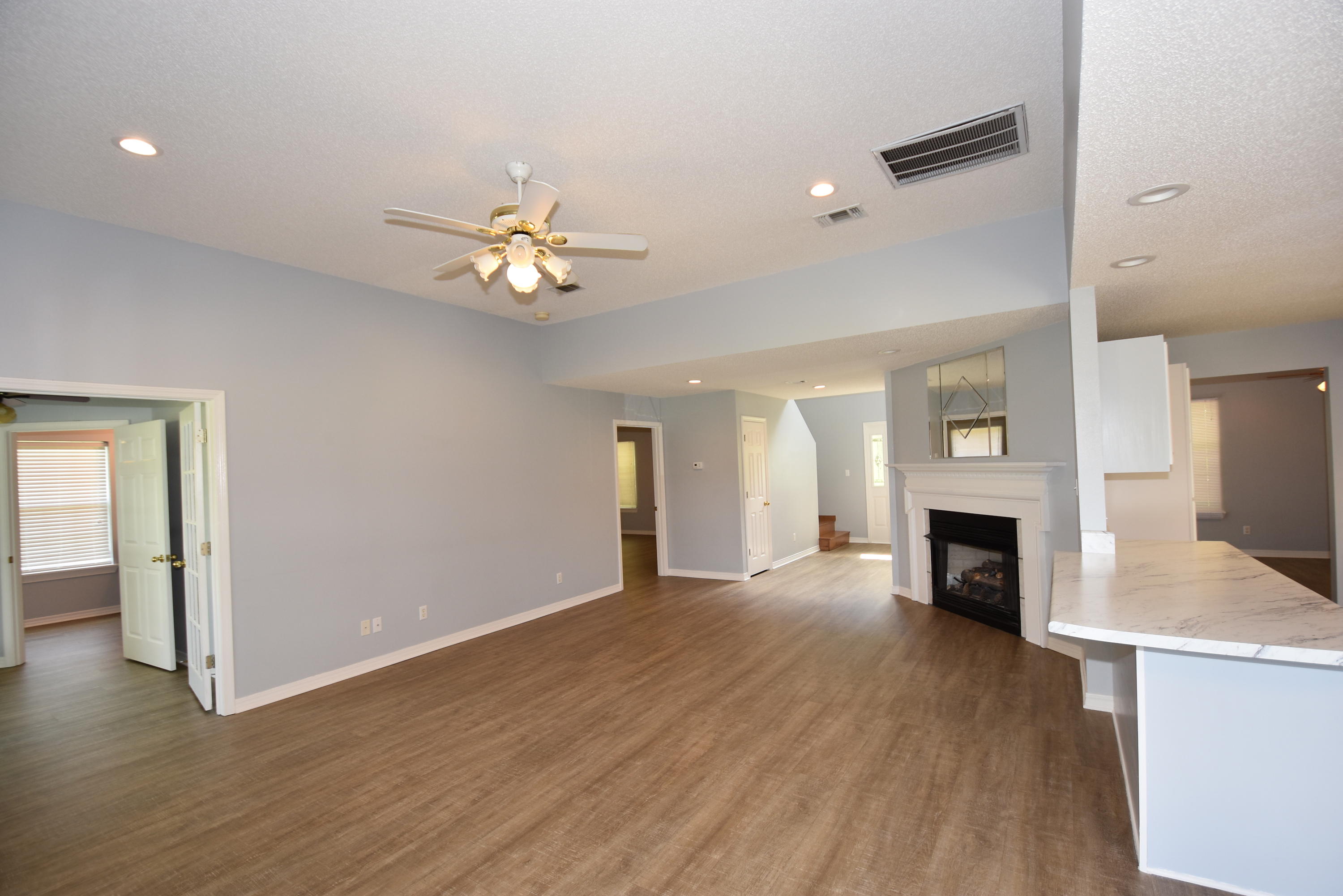 5817 Dairy Road Baker, FL 32531 - Photo 7 of 36 wooden floor in an empty room with a fireplace and a kitchen