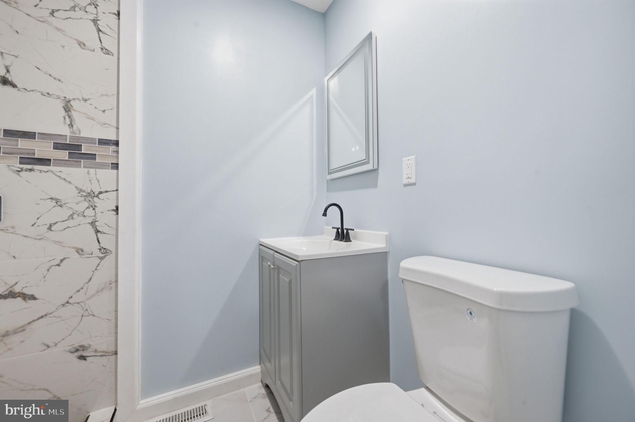 517 Valcour Road Baltimore, MD 21228 - Photo 40 of 47 a white toilet sitting next to a bathroom sink