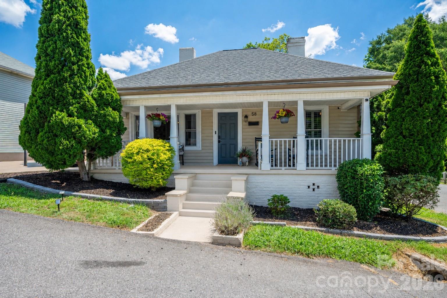 58 Fourth Street Cramerton, NC 28032 - Photo 4 of 44 a front view of a house with a yard and potted plants