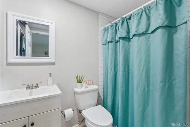 a bathroom with a toilet a sink and a mirror