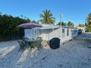 110 Tweedy Pie Terrace Key Largo, FL 33037 - Photo 20 of 21 a view of a chairs and table in backyard