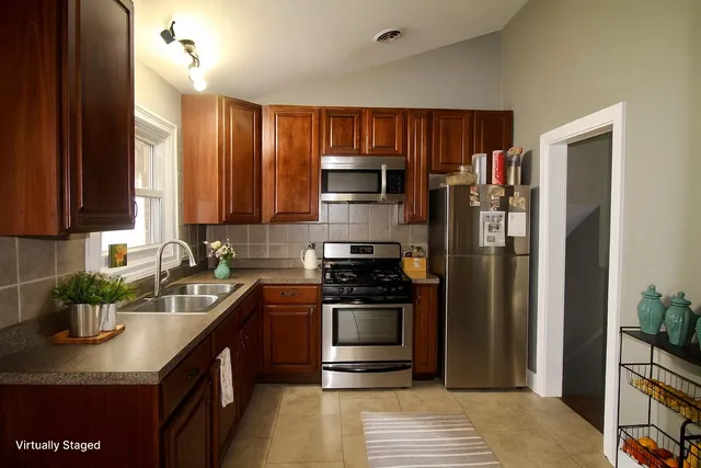 a kitchen with stainless steel appliances granite countertop a stove a refrigerator and a sink