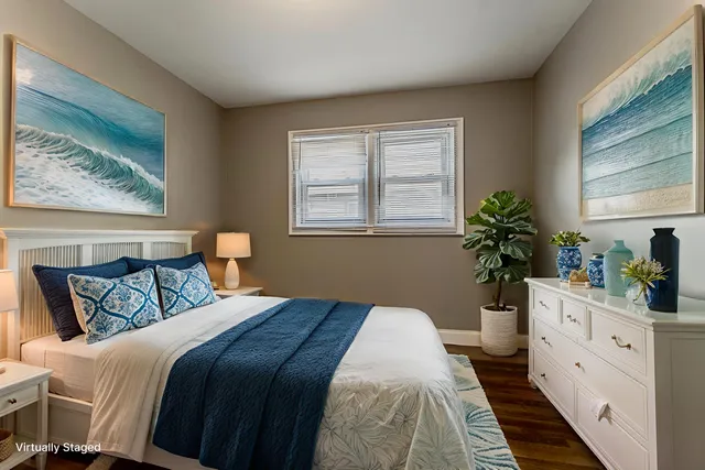 a bedroom with a bed and a potted plant