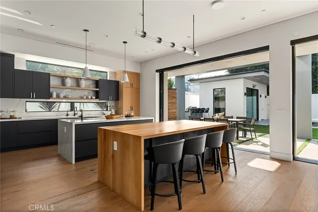 a kitchen with kitchen island granite countertop wooden floor and stainless steel appliances