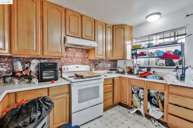 a kitchen filled with white cabinets and white appliances
