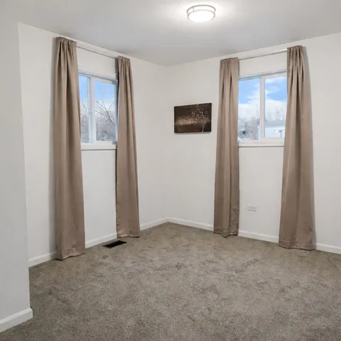 an empty room with windows and closet