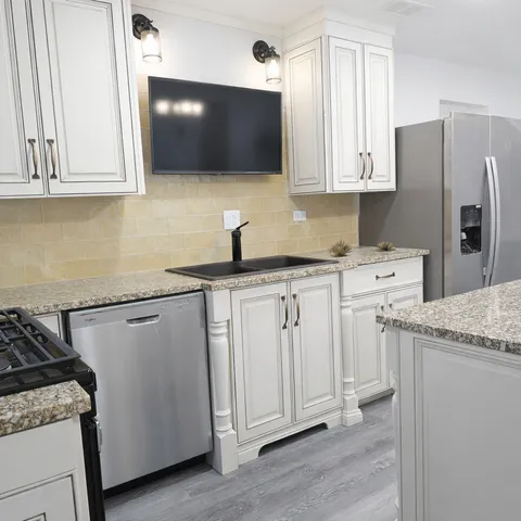 a kitchen with stainless steel appliances white cabinets and a granite counter tops