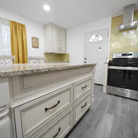 a kitchen with granite countertop white cabinets and white appliances