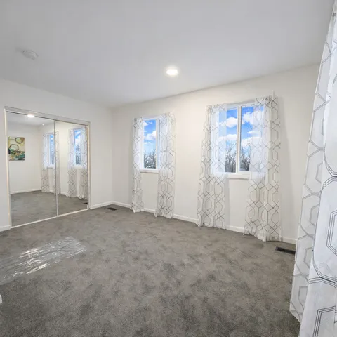 an empty room with windows and closet