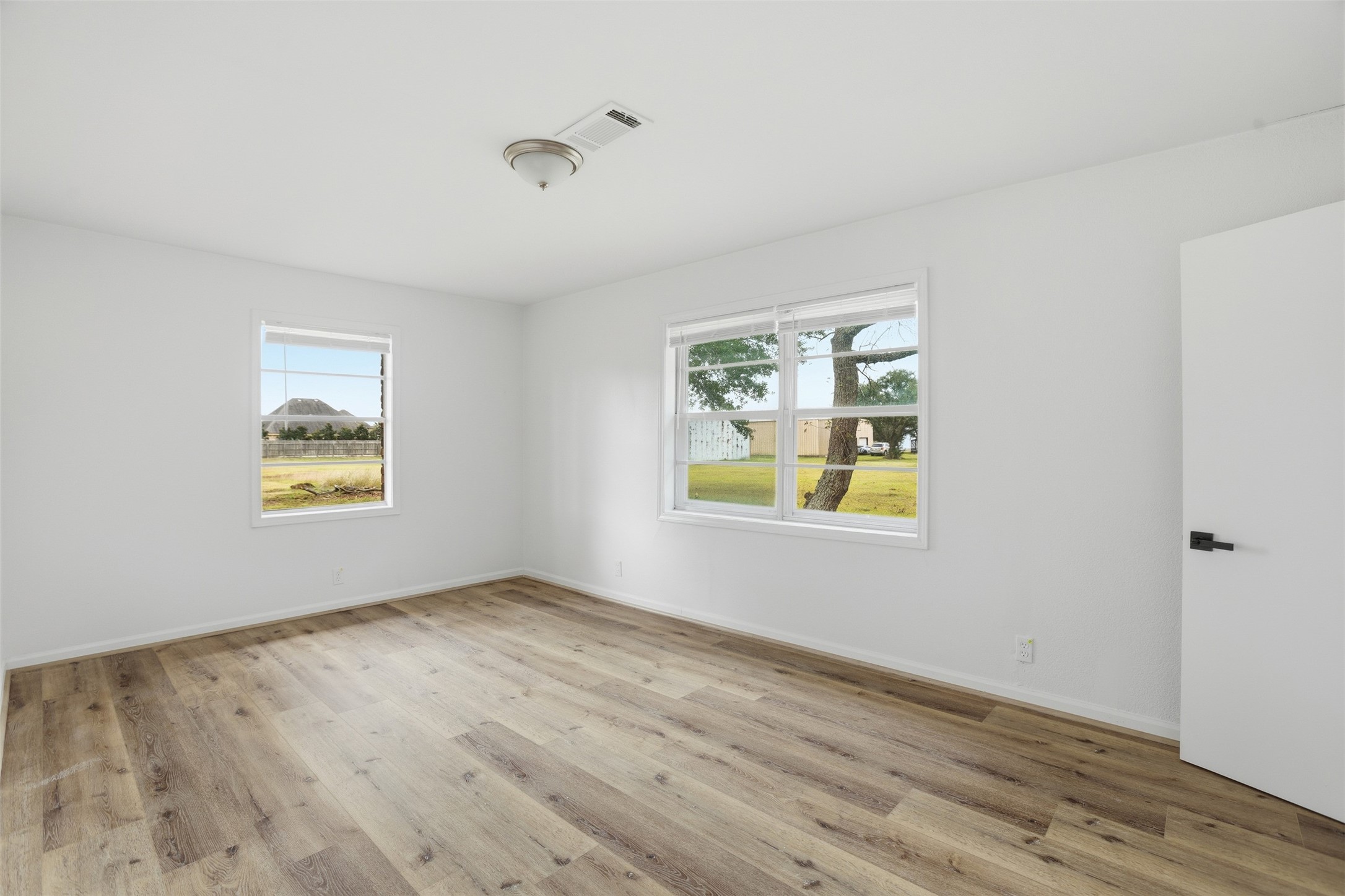 2751 Piper Road Pearland, TX 77581 - Photo 13 of 24 a view of an empty room with window and wooden floor