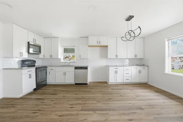 a kitchen with granite countertop white cabinets and white appliances