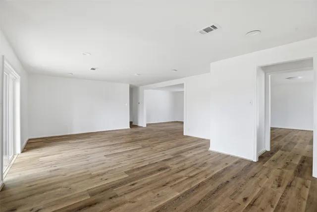 a view of empty room with wooden floor