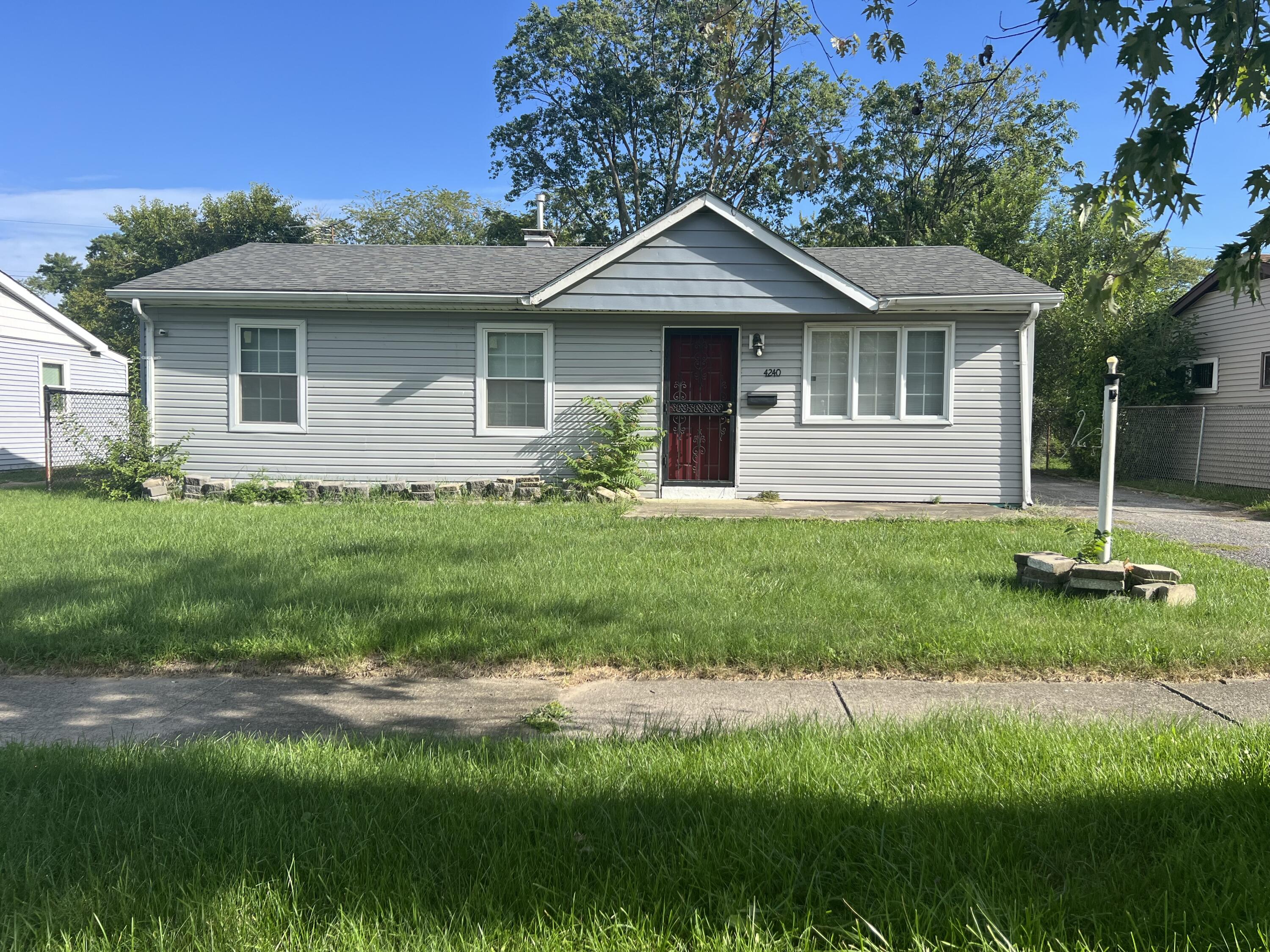 a front view of a house with a yard and trees