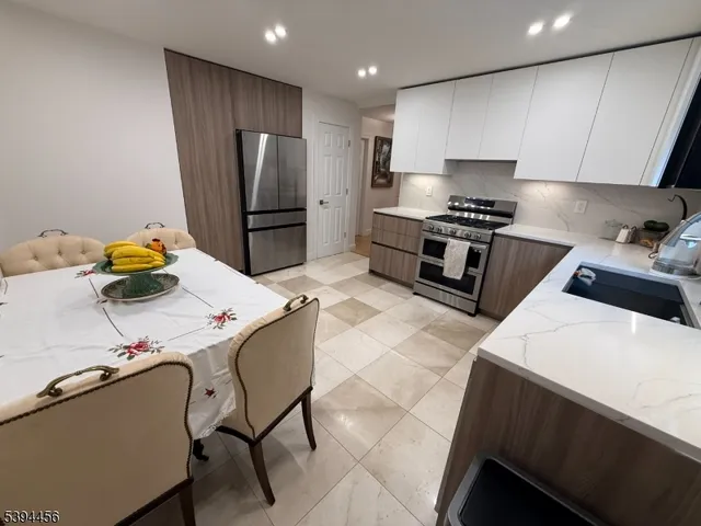 a kitchen with stainless steel appliances kitchen island granite countertop a sink refrigerator and stove