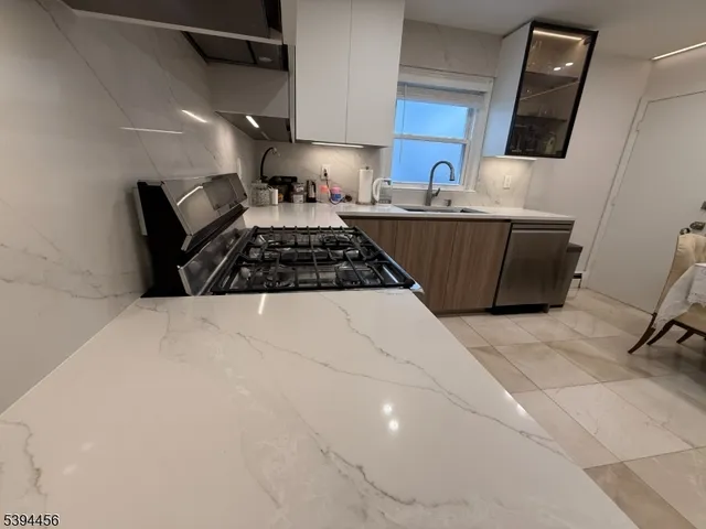 a kitchen with a sink a stove and cabinets