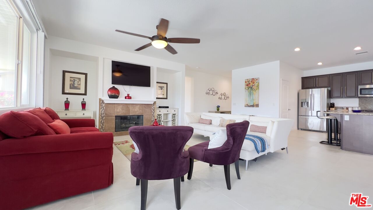 84330 Tramonto Way Indio, CA 92203 - Photo 2 of 18 a living room with furniture a fireplace and a flat screen tv