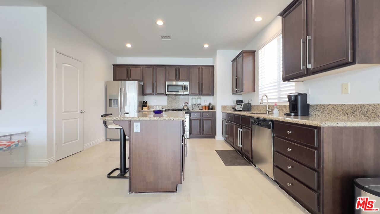 84330 Tramonto Way Indio, CA 92203 - Photo 3 of 18 a kitchen with a refrigerator a sink and cabinets