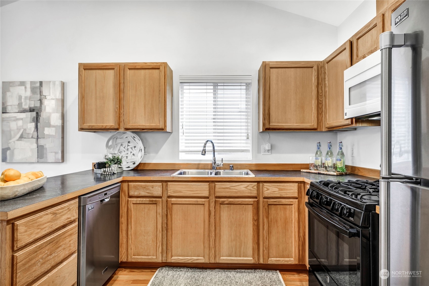 8317 233rd Street Southwest, Unit 3 Edmonds, WA 98026 - Photo 12 of 31 a kitchen with stainless steel appliances a sink stove and cabinets