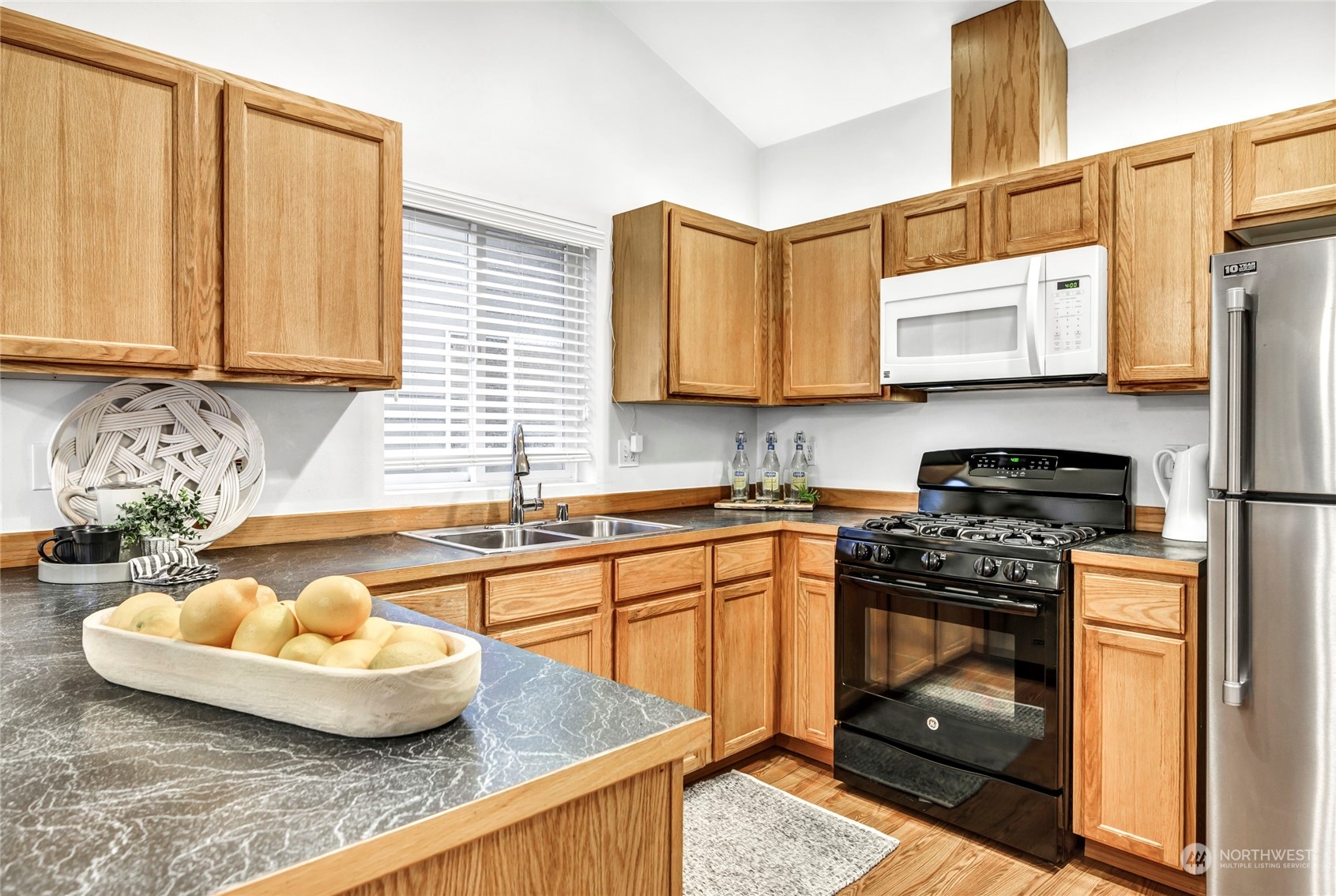 8317 233rd Street Southwest, Unit 3 Edmonds, WA 98026 - Photo 10 of 31 a kitchen with granite countertop a sink a stove and wooden cabinets