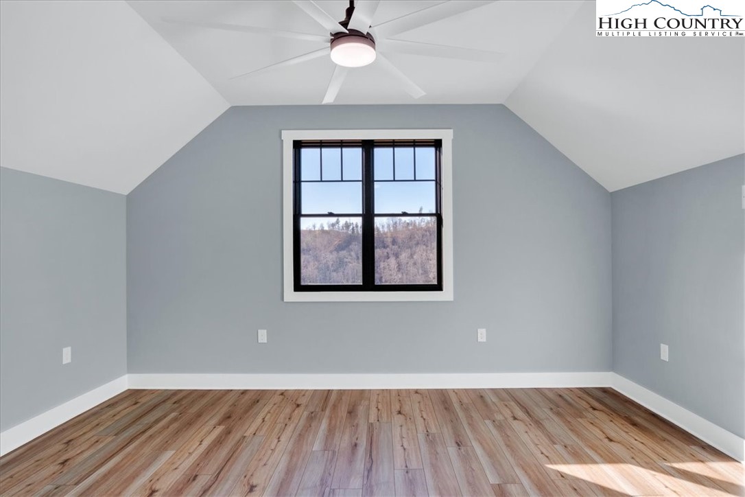 1518 Moxley Ridge Road Independence, VA 24348 - Photo 33 of 50 an empty room with wooden floor chandelier fan and windows